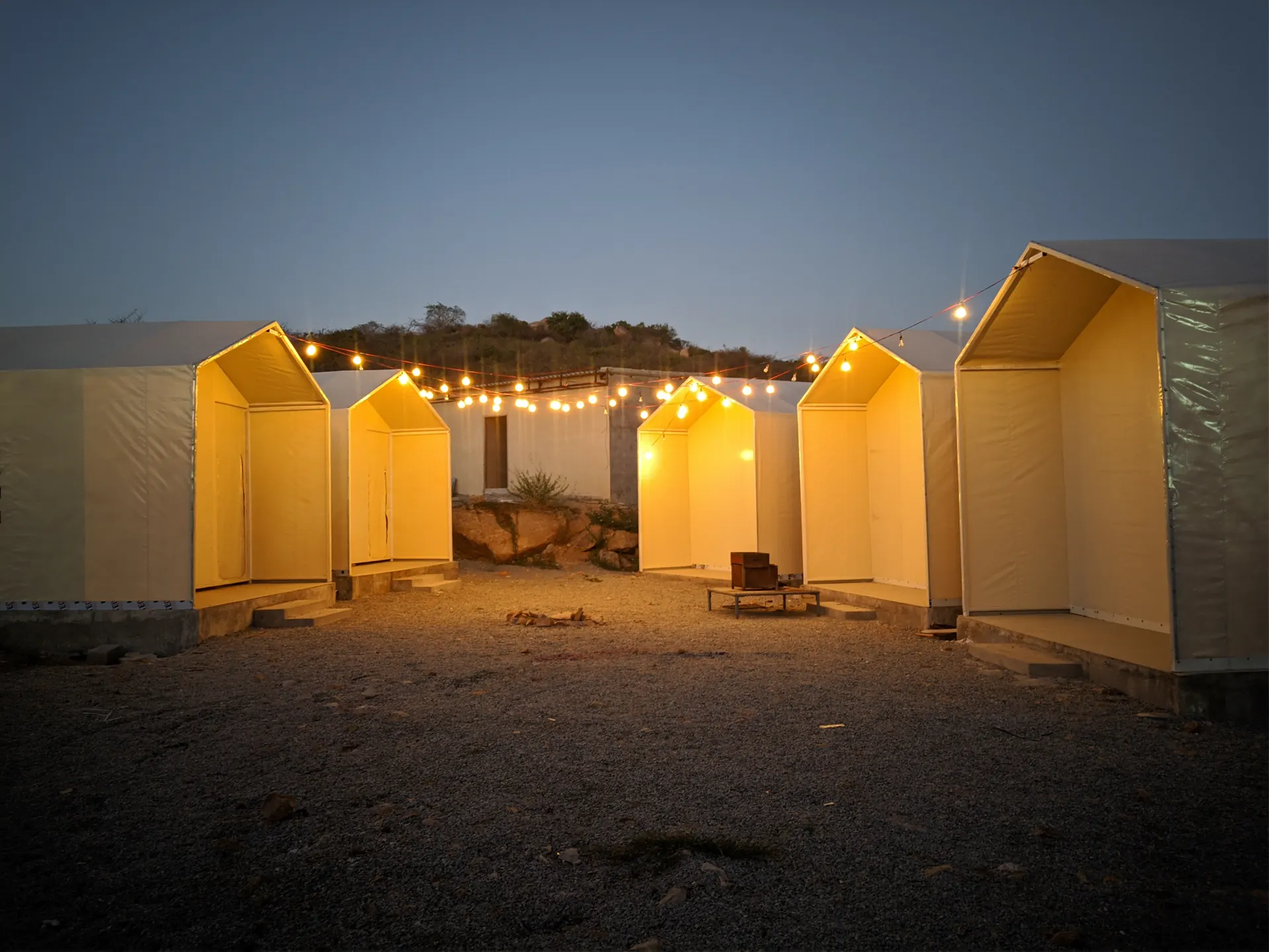 Fairy-lit camping cabins at Keesara at dusk