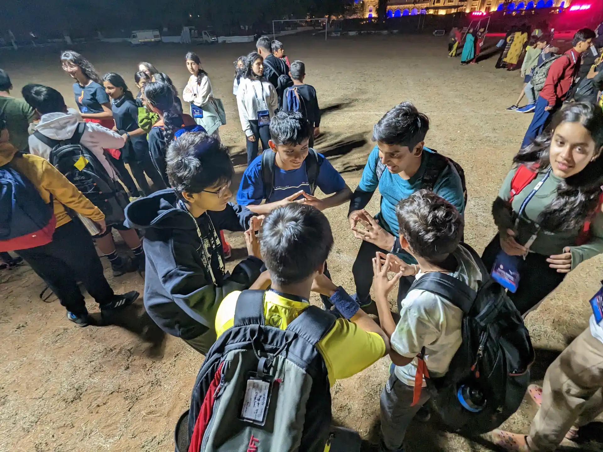 Instructor guiding children in orange safety vests through an outdoor adventure activity