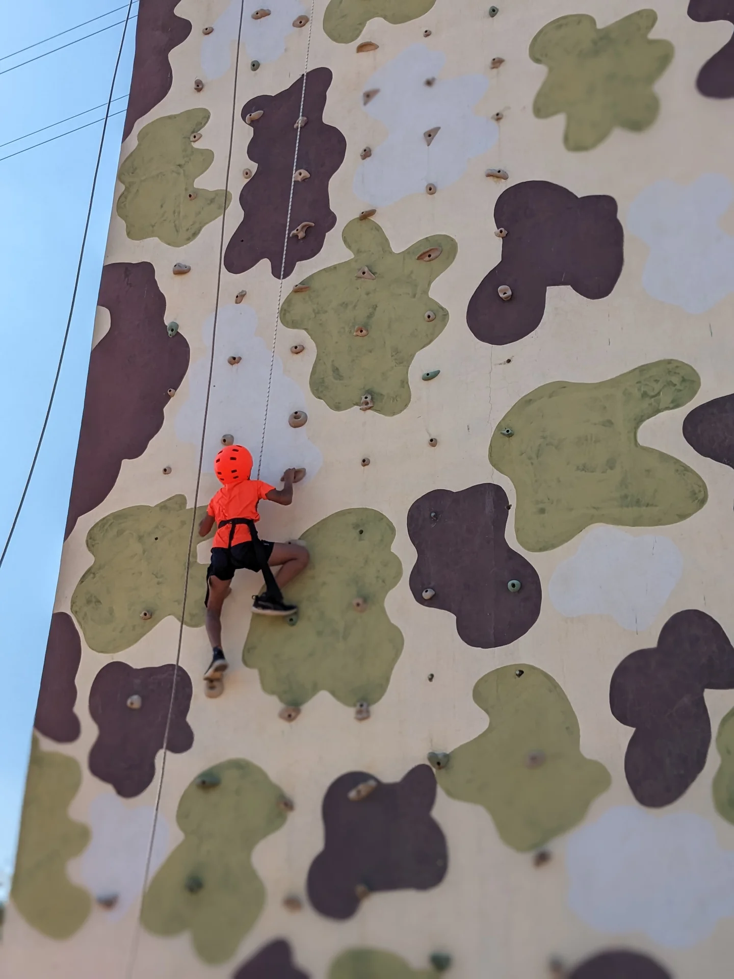 Climber on a large artificial rock-climbing wall